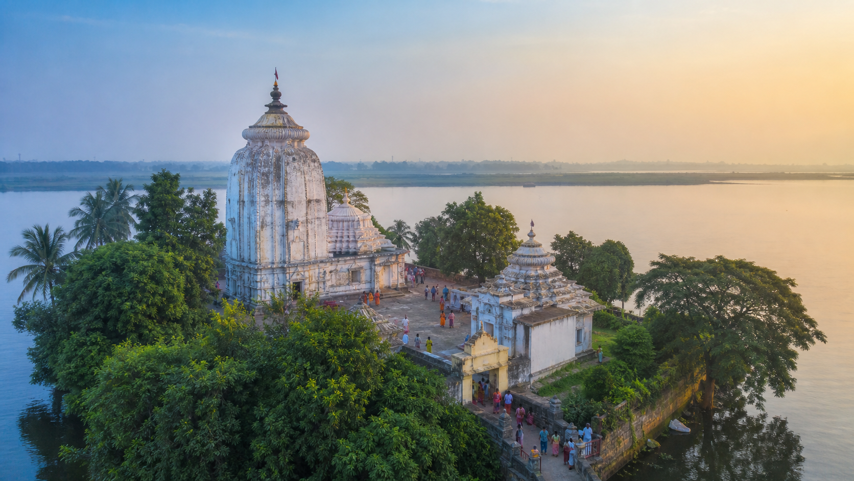 Dhabaleswar Temple rises among trees on an island surrounded by the Mahanadi River at dawn.