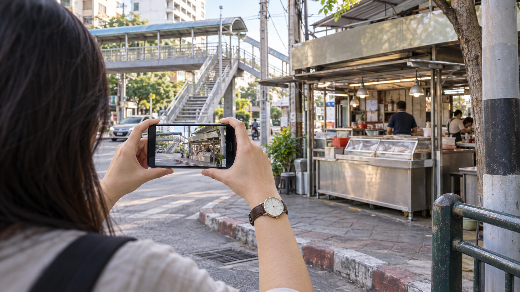 A citizen uses a phone to document a covered food stall together with nearby railway and street landmarks.