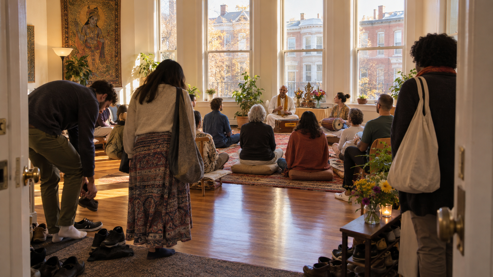People gather on cushions and chairs for a devotional teaching program in a Washington, DC community hall.