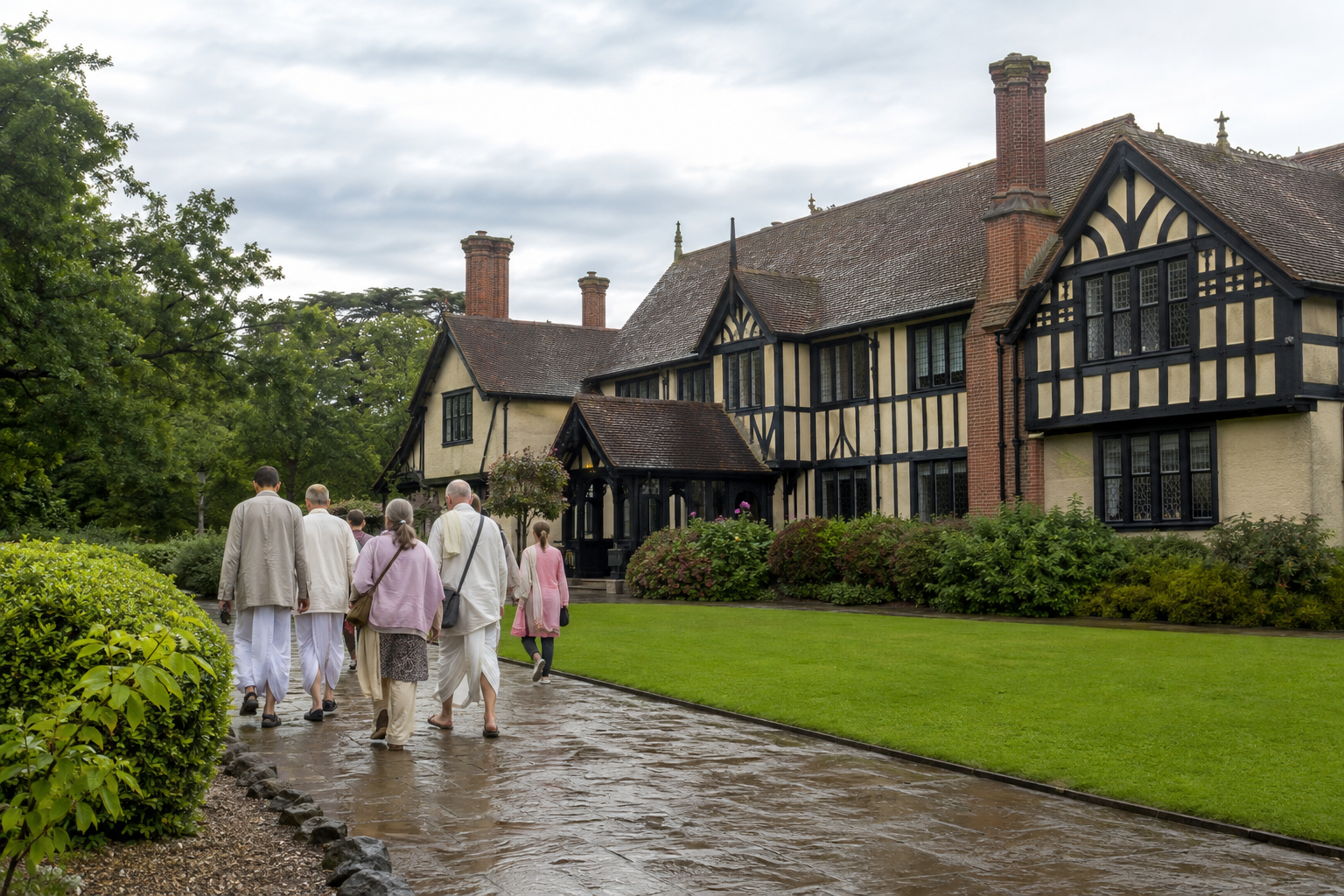 Visitors approach Bhaktivedanta Manor, a timber-framed country house surrounded by green lawns and mature trees.