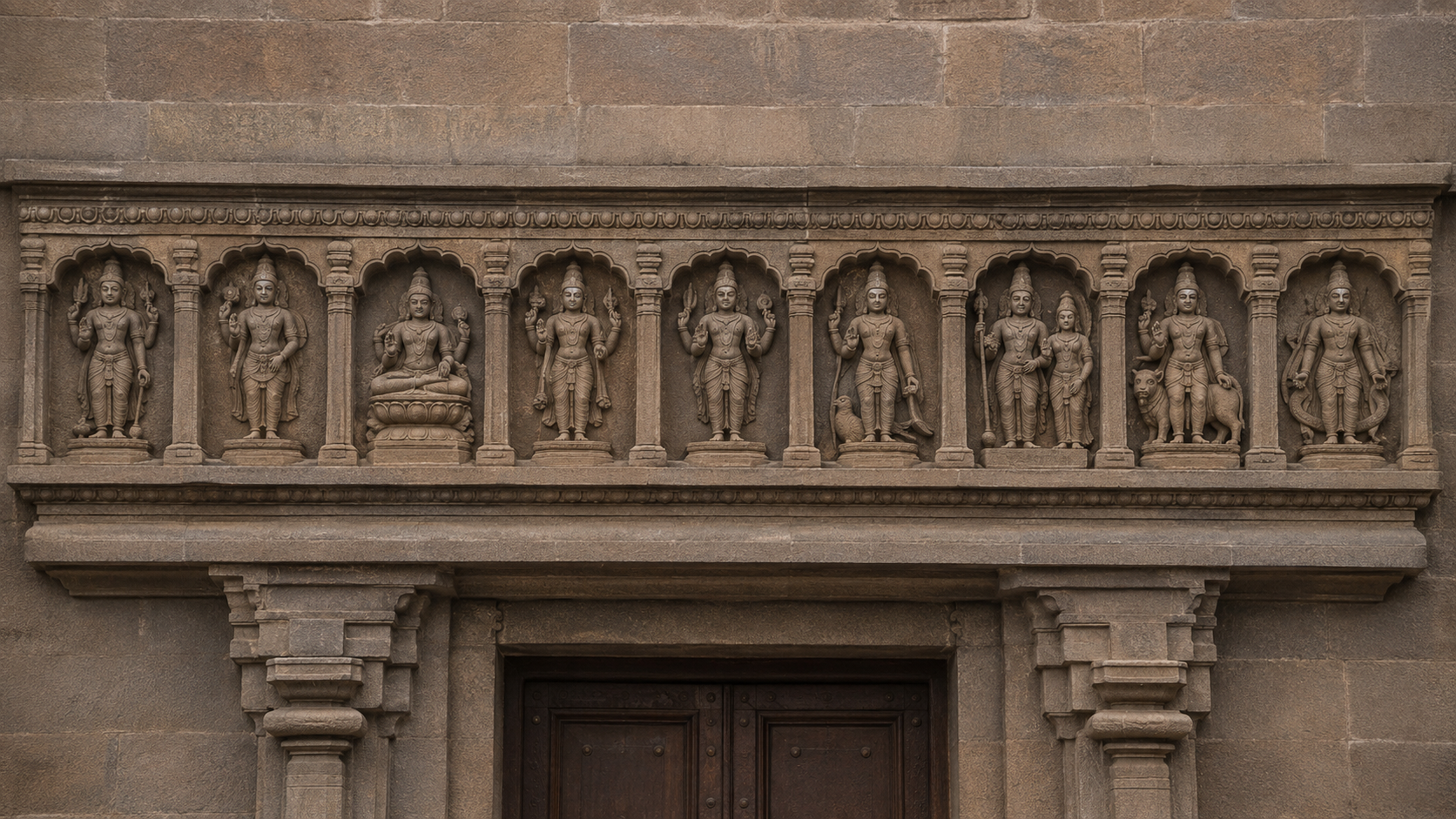 A straight-on view of a complete Navagraha lintel, with a female consort beside one graha figure within the larger sequence.